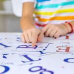 The child learns English letters. Selective focus.