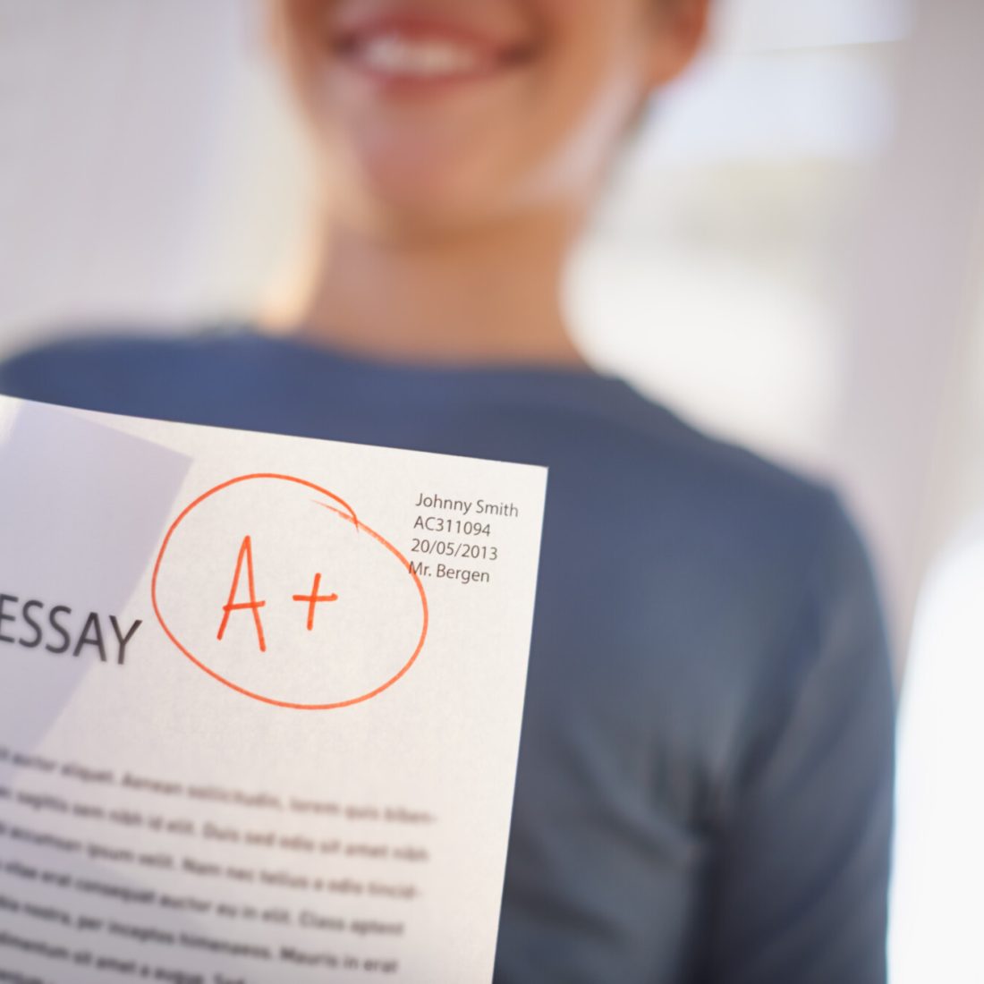 Easy A. Shot of a proud young boy holding up his essay that got him an A.