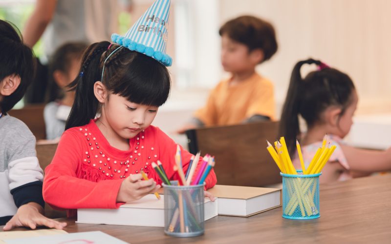 Preschool Asian Girl Intend Drawing on Paper in Hobby Art Hour on Summer Classroom.